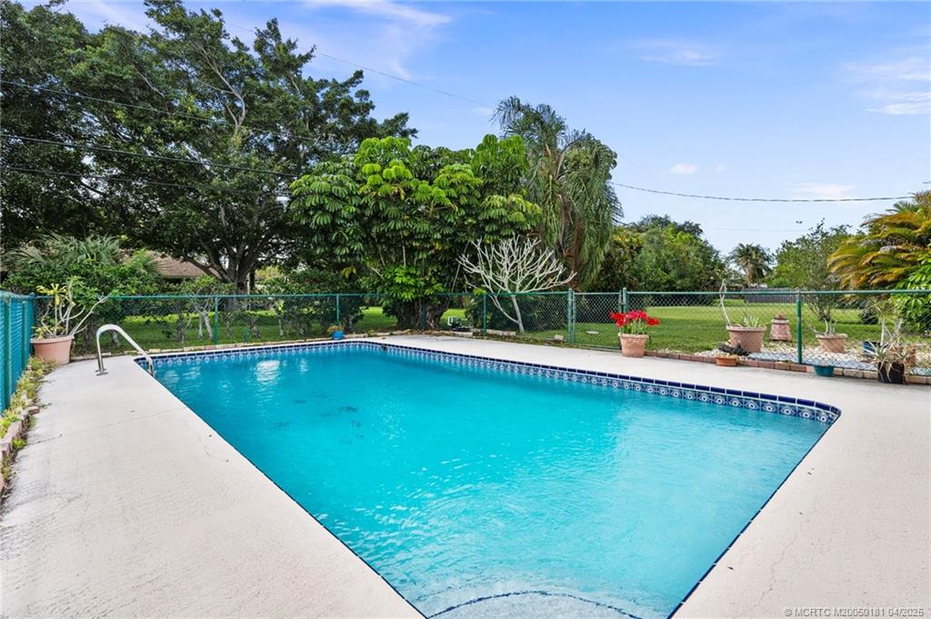 2416 North W Everglades Boulevard Stuart, FL 34994 - Photo 2 of 9 a view of a swimming pool with a patio