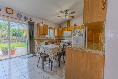 a living room with a table chairs and a refrigerator