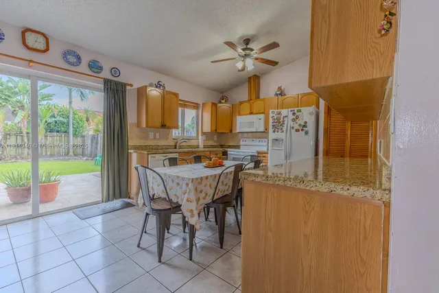a living room with a table chairs and a refrigerator