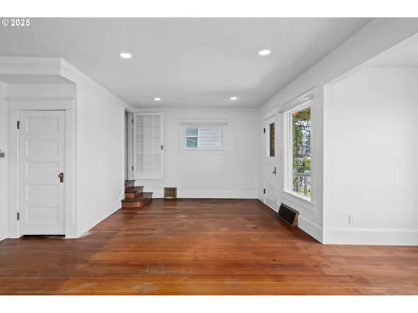 a view of an empty room with wooden floor