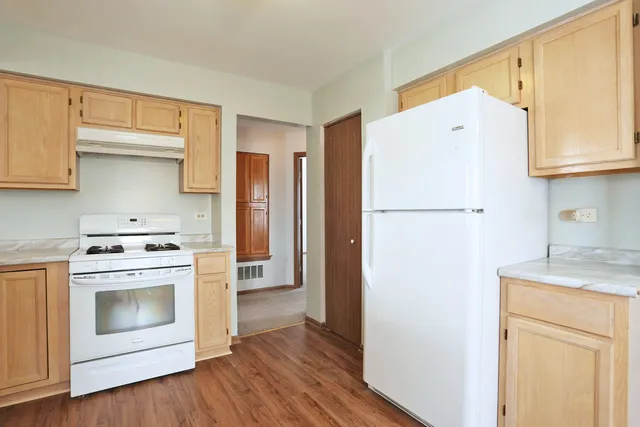 a kitchen with a white stove top oven and refrigerator
