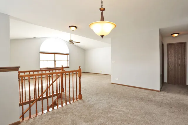 a view of staircase with railing and a chandelier