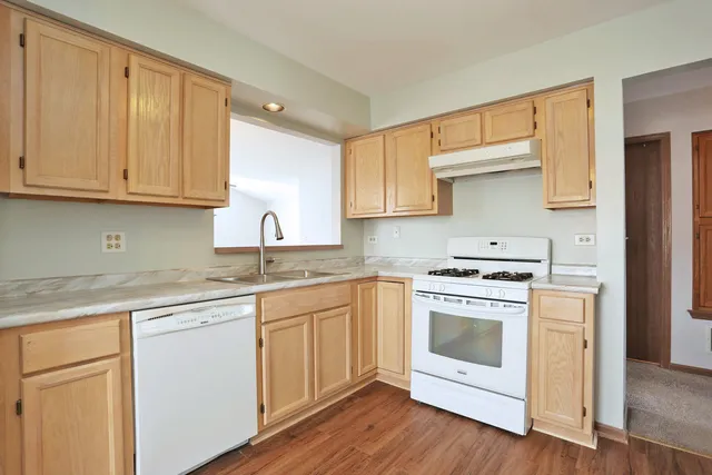 a kitchen with white cabinets and white appliances
