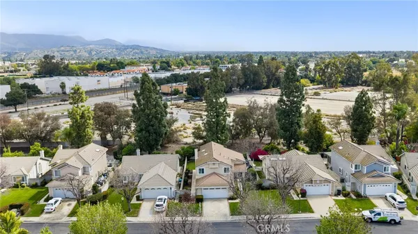 an aerial view of a house with a garden and lots of residential buildings ocean and mountain view