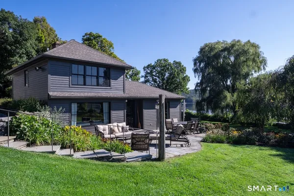 a front view of a house with garden and trees