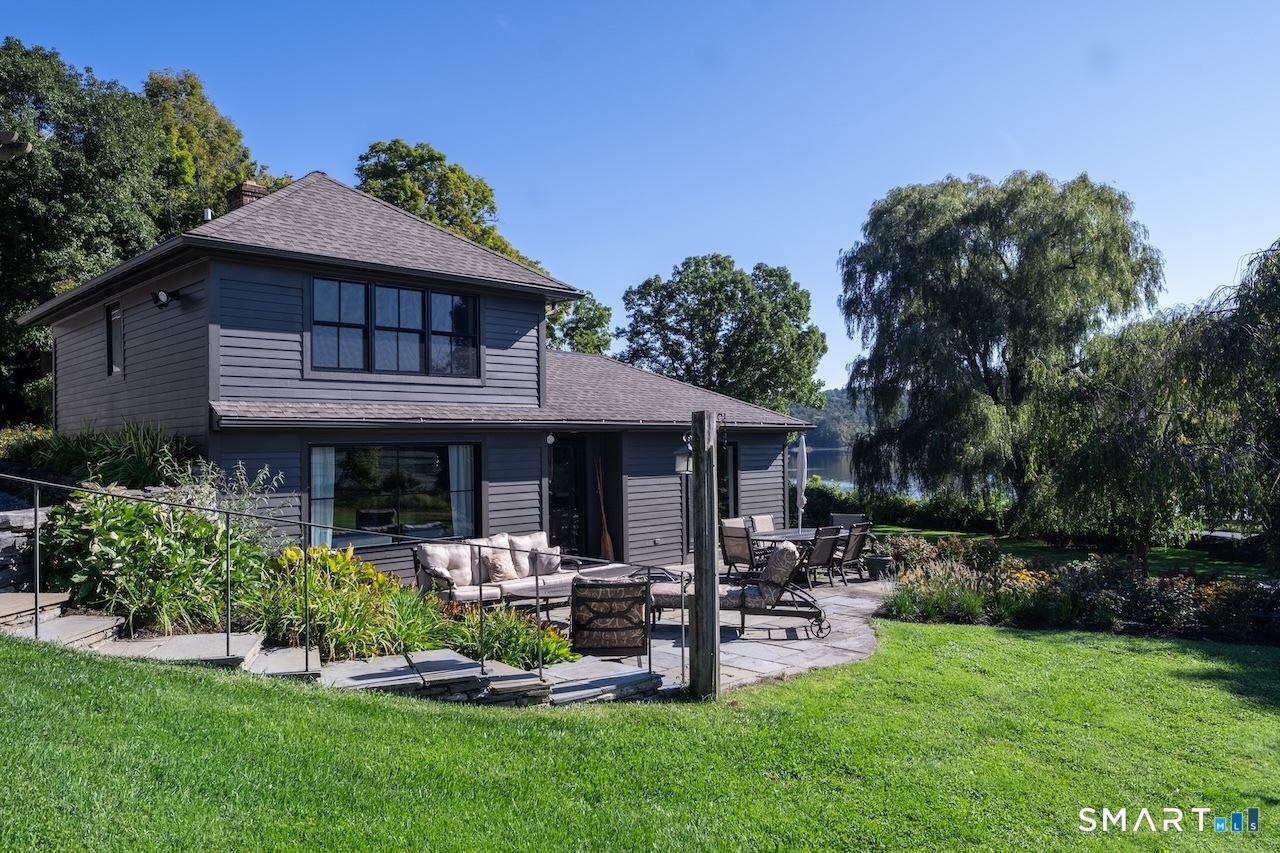 a front view of a house with garden and trees