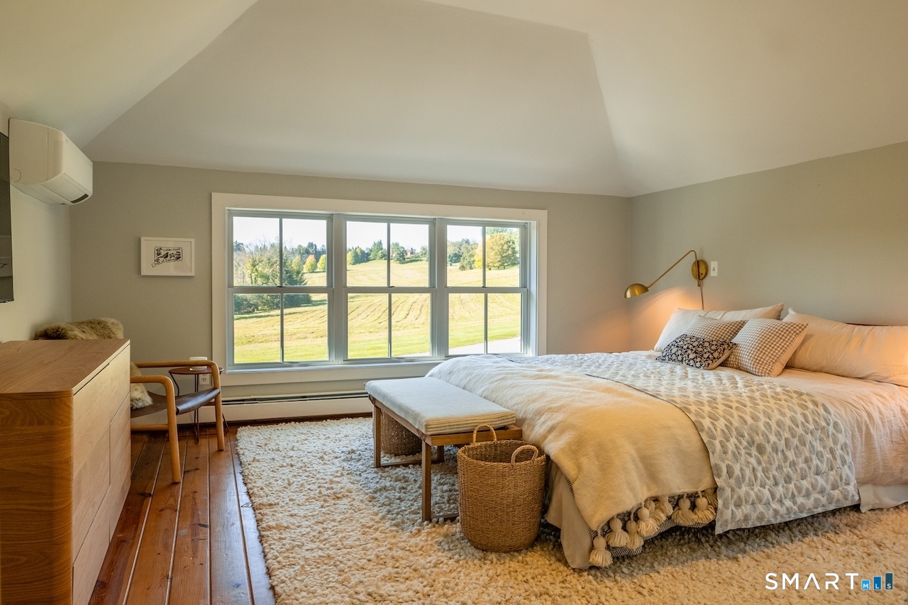 69 Mudge Pond Road Sharon, CT 06069 - Photo 16 of 28 a bedroom with a bed and a table chair