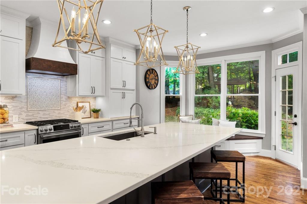 1111 Lytton Lane Matthews, NC 28104 - Photo 17 of 48 a kitchen with stainless steel appliances a stove a table a chandelier and a window