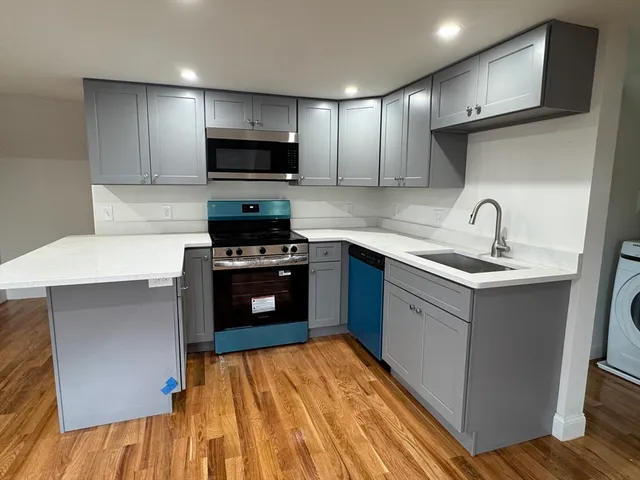 a kitchen with stainless steel appliances granite countertop a sink stove and microwave