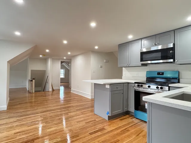 a kitchen with stainless steel appliances a stove a sink and a microwave