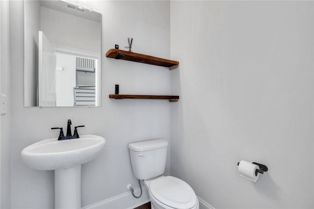 226 Holly Br Road Piedmont, SC 29673 - Photo 17 of 44 A well-appointed powder room with a pedestal sink and rustic wooden shelving.