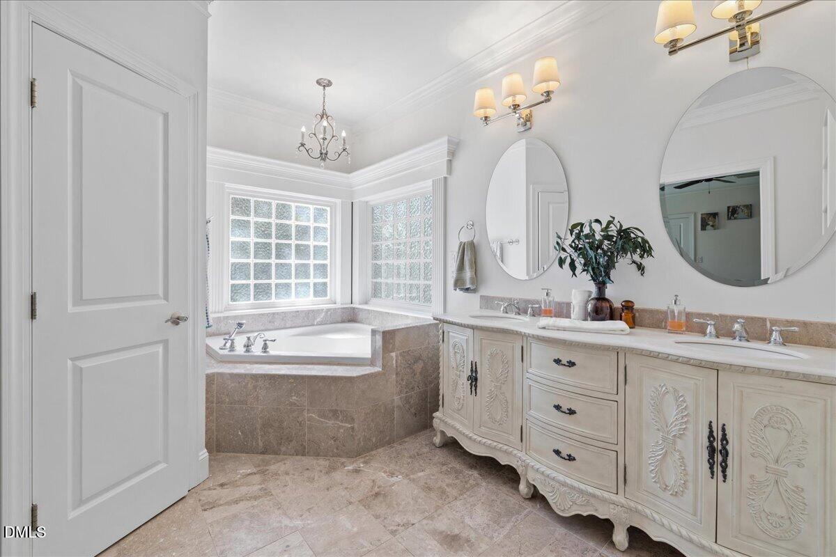 1304 Flying Hawk Road Apex, NC 27523 - Photo 23 of 52 a spacious bathroom with a double vanity sink mirror and bathtub