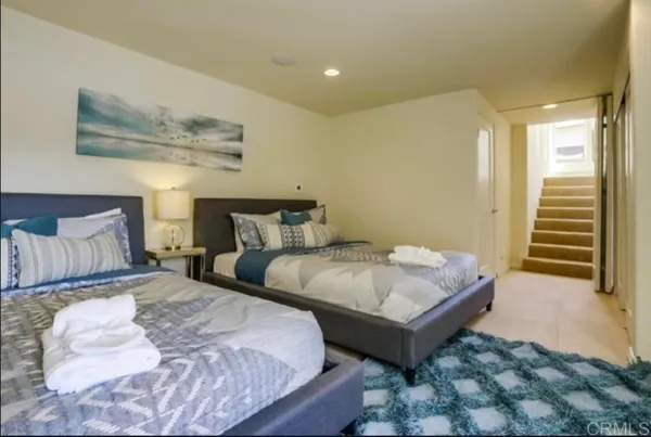 a bedroom with two beds and painting on the wall