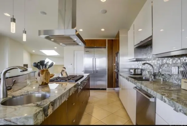 a kitchen with counter top space a sink and stainless steel appliances