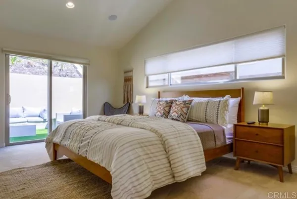 a bedroom with a bed and large window