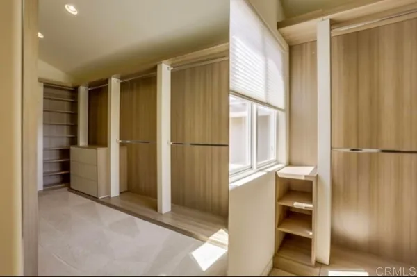 a view of walk in closet with empty racks