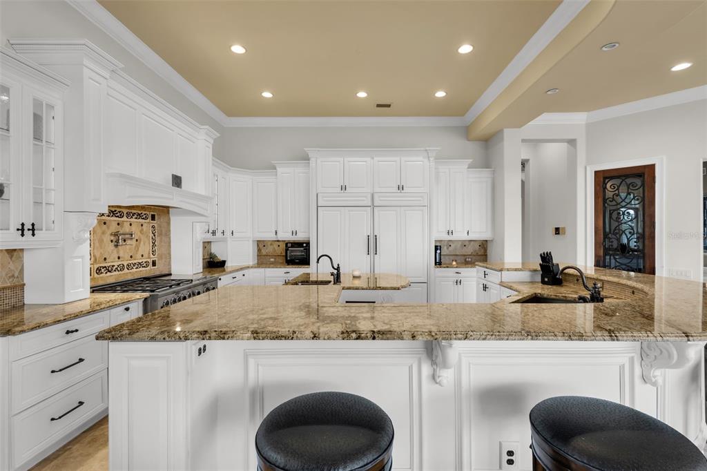 5417 Osprey Isle Lane Windermere, FL 34786 - Photo 12 of 45 a kitchen with kitchen island granite countertop wooden cabinets and a granite counter tops