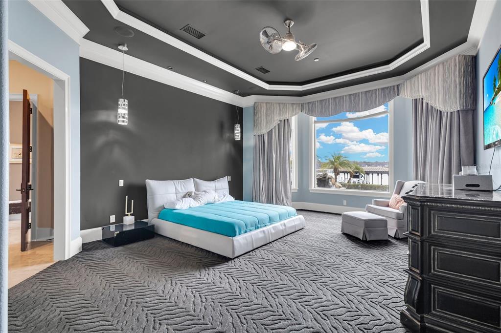 5417 Osprey Isle Lane Windermere, FL 34786 - Photo 23 of 45 a bedroom with a bed and glass windows