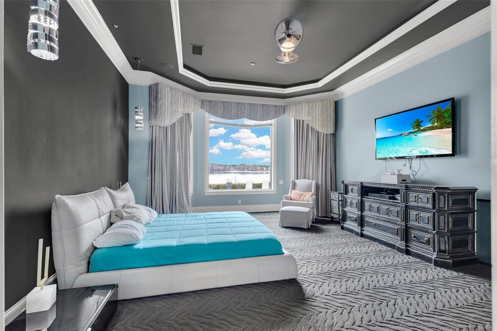 5417 Osprey Isle Lane Windermere, FL 34786 - Photo 25 of 45 a bedroom with a bed and glass windows