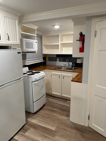 a kitchen with white cabinets and white appliances