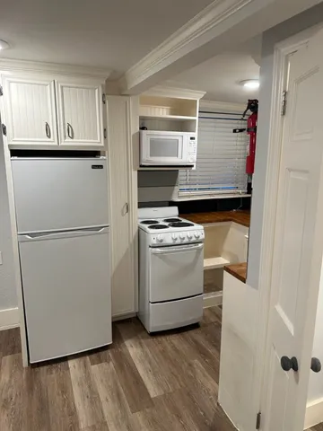 a kitchen with white cabinets and white appliances