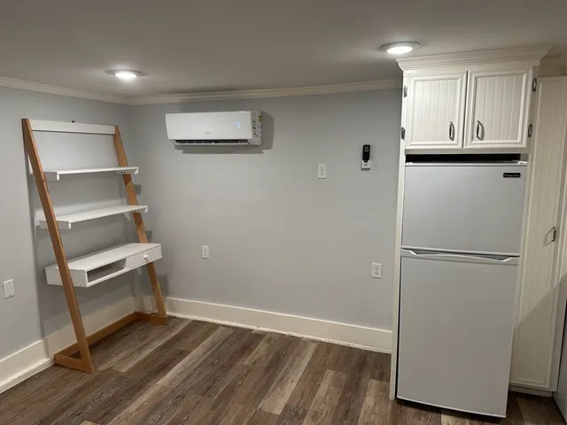 a view of a kitchen with wooden floor and cabinets