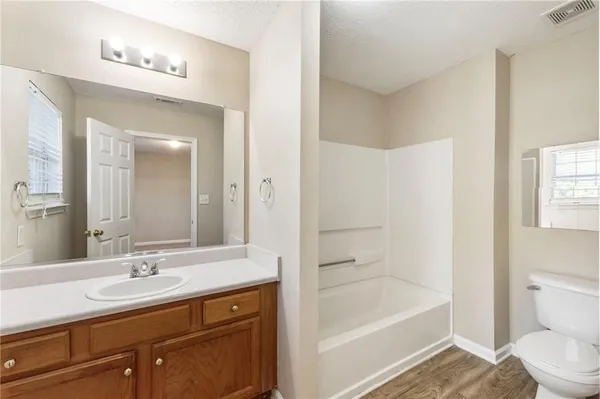 a bathroom with a tub sink toilet and a mirror