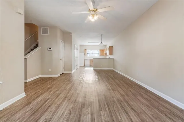a view of a kitchen with wooden floor and a ceiling fan