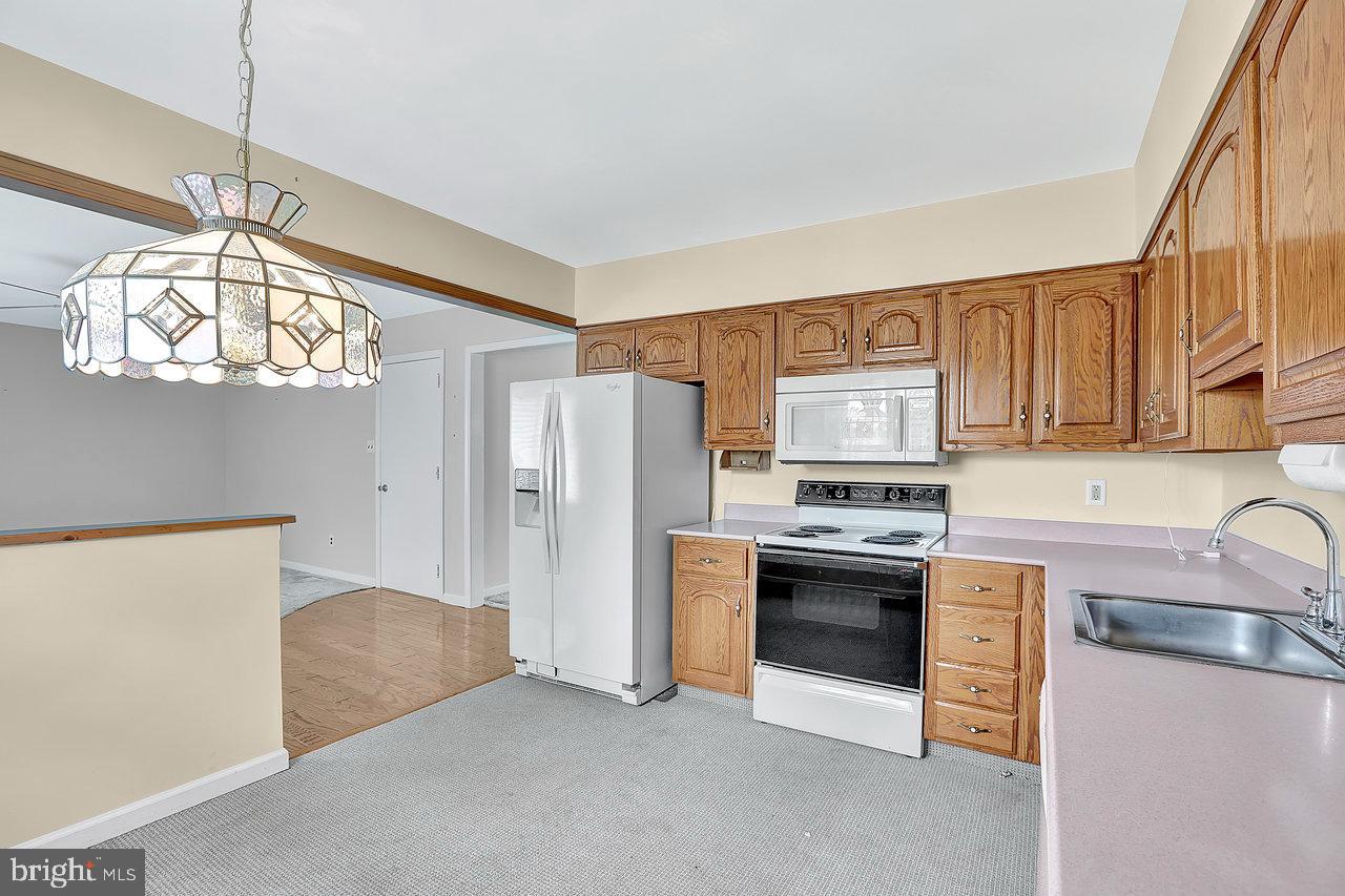 114 Pelham Road Delran, NJ 08075 - Photo 8 of 18 a kitchen with stainless steel appliances granite countertop a refrigerator a stove a sink dishwasher and a dining table with wooden floor