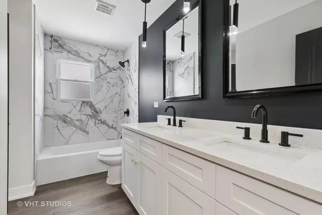 a bathroom with a double vanity sink mirror double and bathtub
