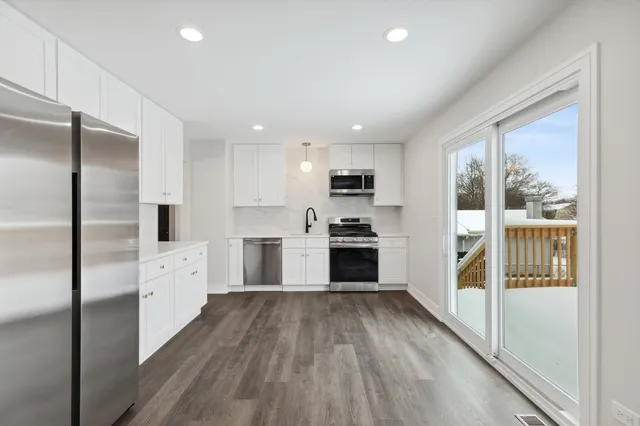 a kitchen with white cabinets and stainless steel appliances