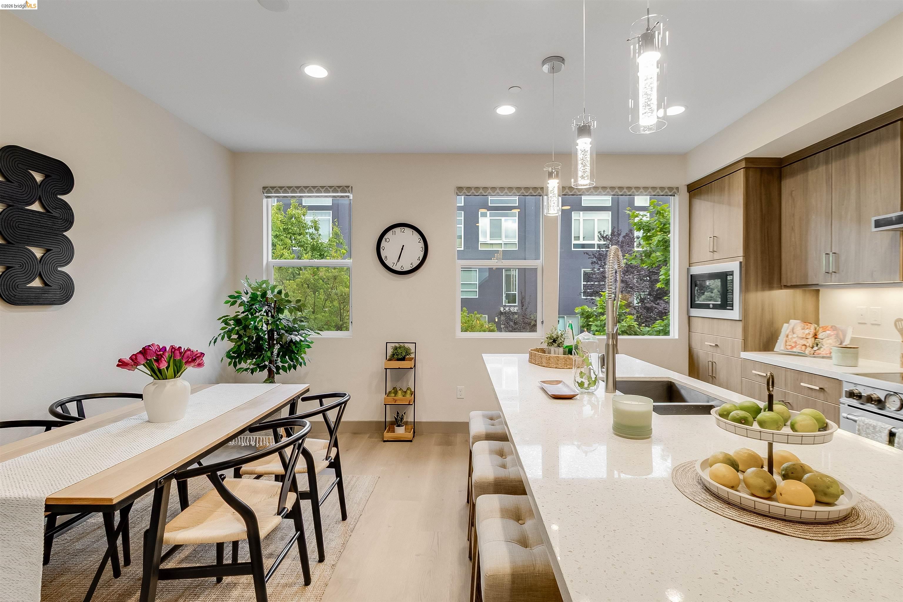 1357 Pullman Way Oakland, CA 94607 - Photo 14 of 37 Modern kitchen and dining area featuring wood-finish flooring, quartz countertops, and contemporary pendant lighting