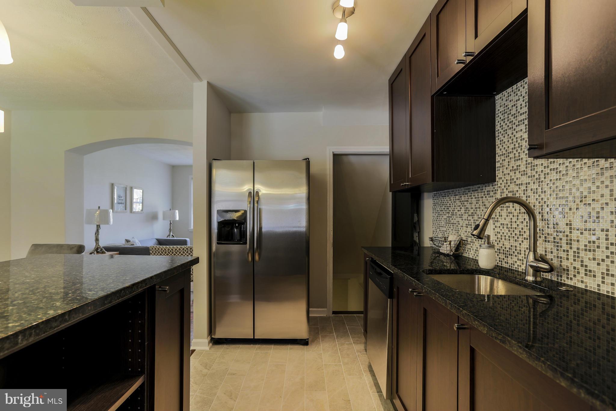 6923 Belclare Road Baltimore, MD 21222 - Photo 12 of 23 a kitchen with granite countertop a refrigerator and a sink