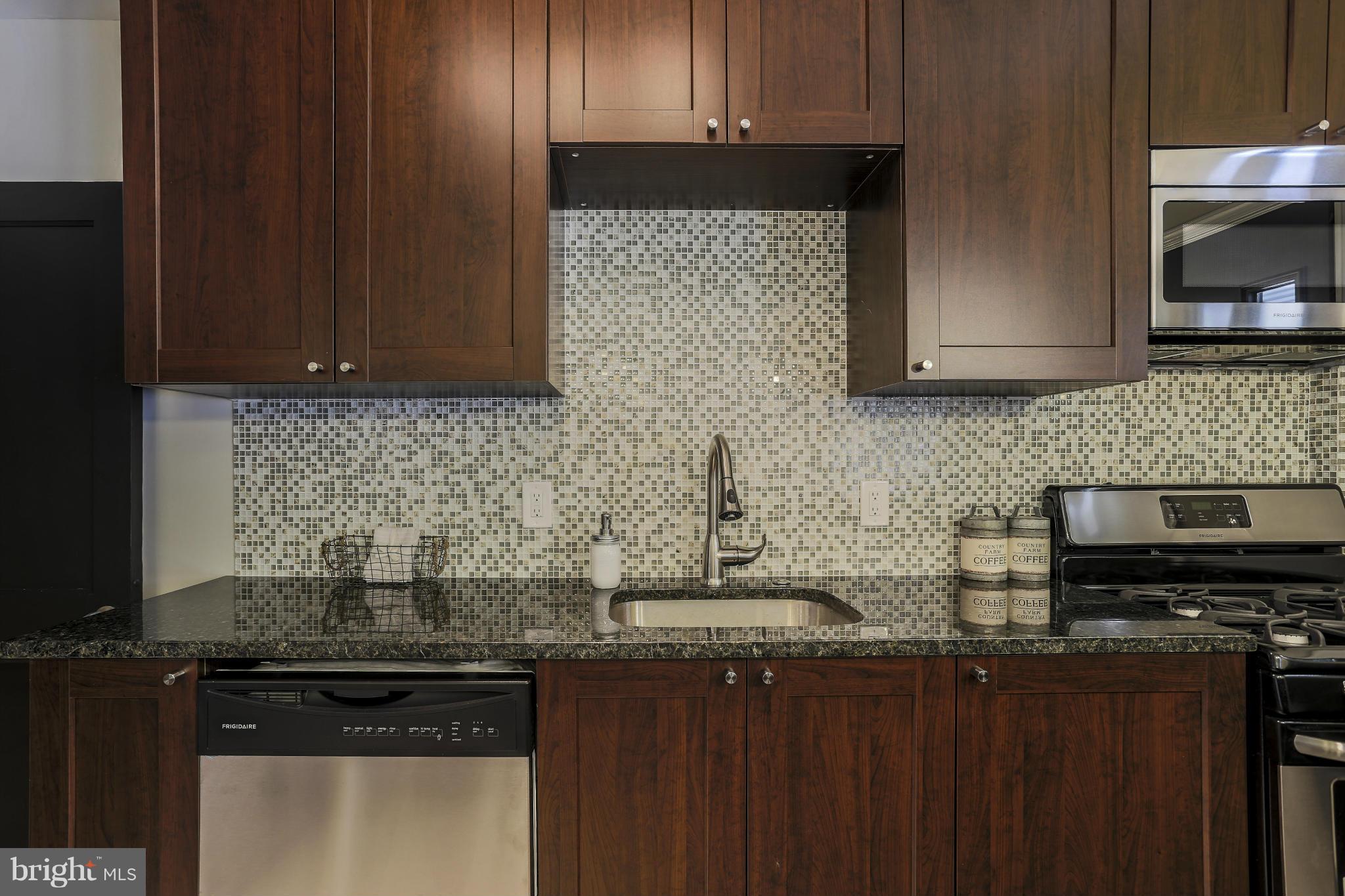 6923 Belclare Road Baltimore, MD 21222 - Photo 14 of 23 a kitchen with stainless steel appliances granite countertop a stove a sink and a microwave