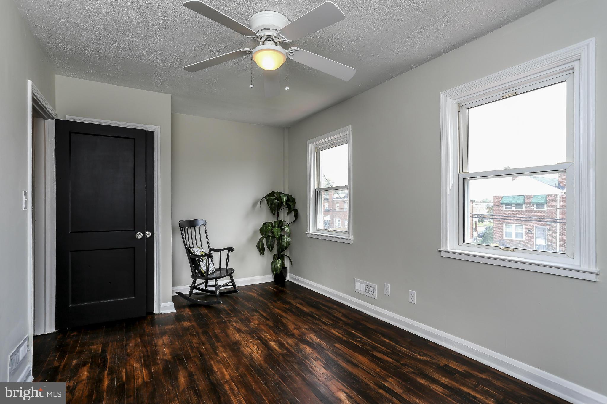 6923 Belclare Road Baltimore, MD 21222 - Photo 19 of 23 a view of an empty room with a window and wooden floor