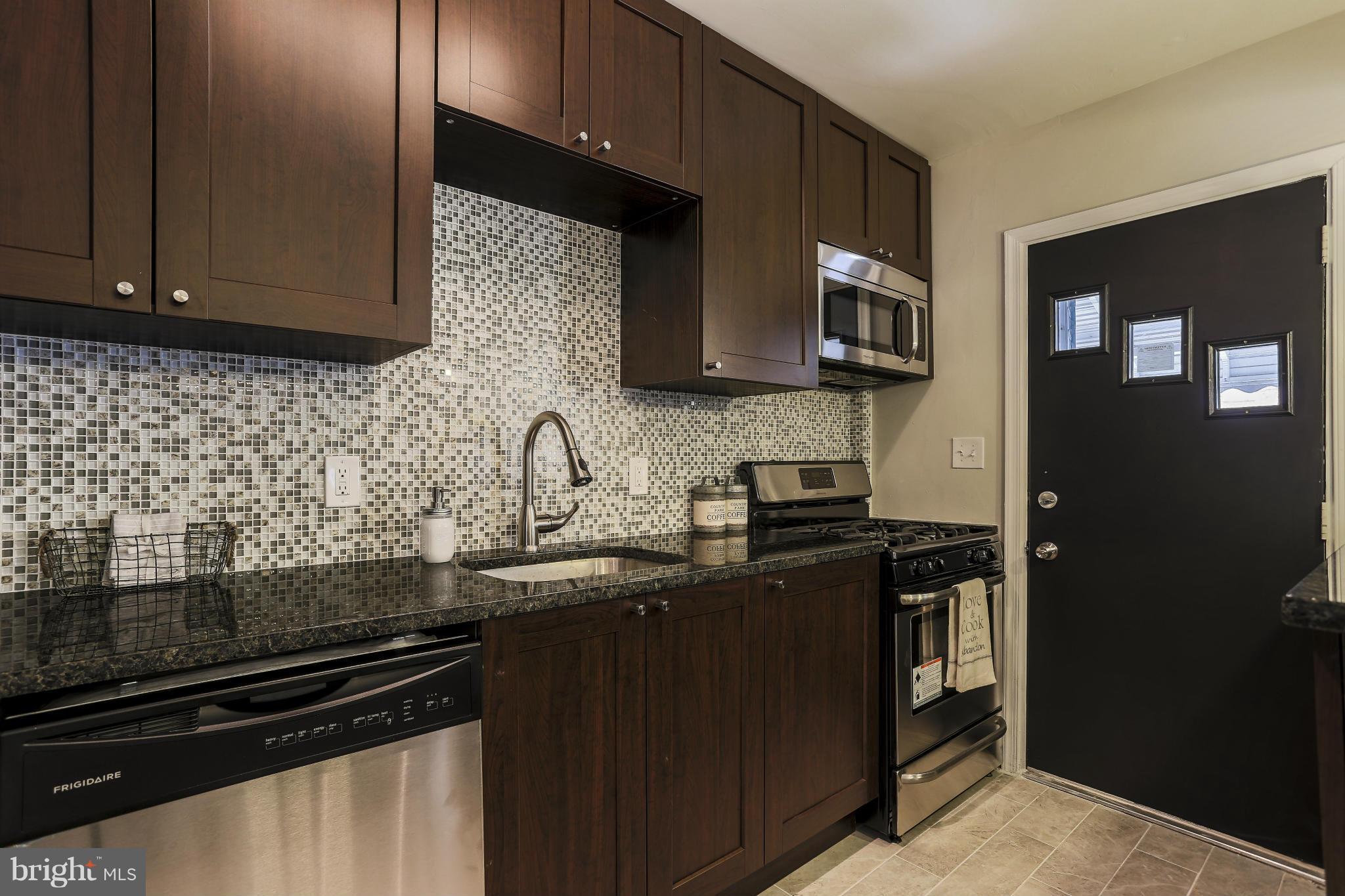 6923 Belclare Road Baltimore, MD 21222 - Photo 9 of 23 a kitchen with stainless steel appliances wooden cabinets and a sink