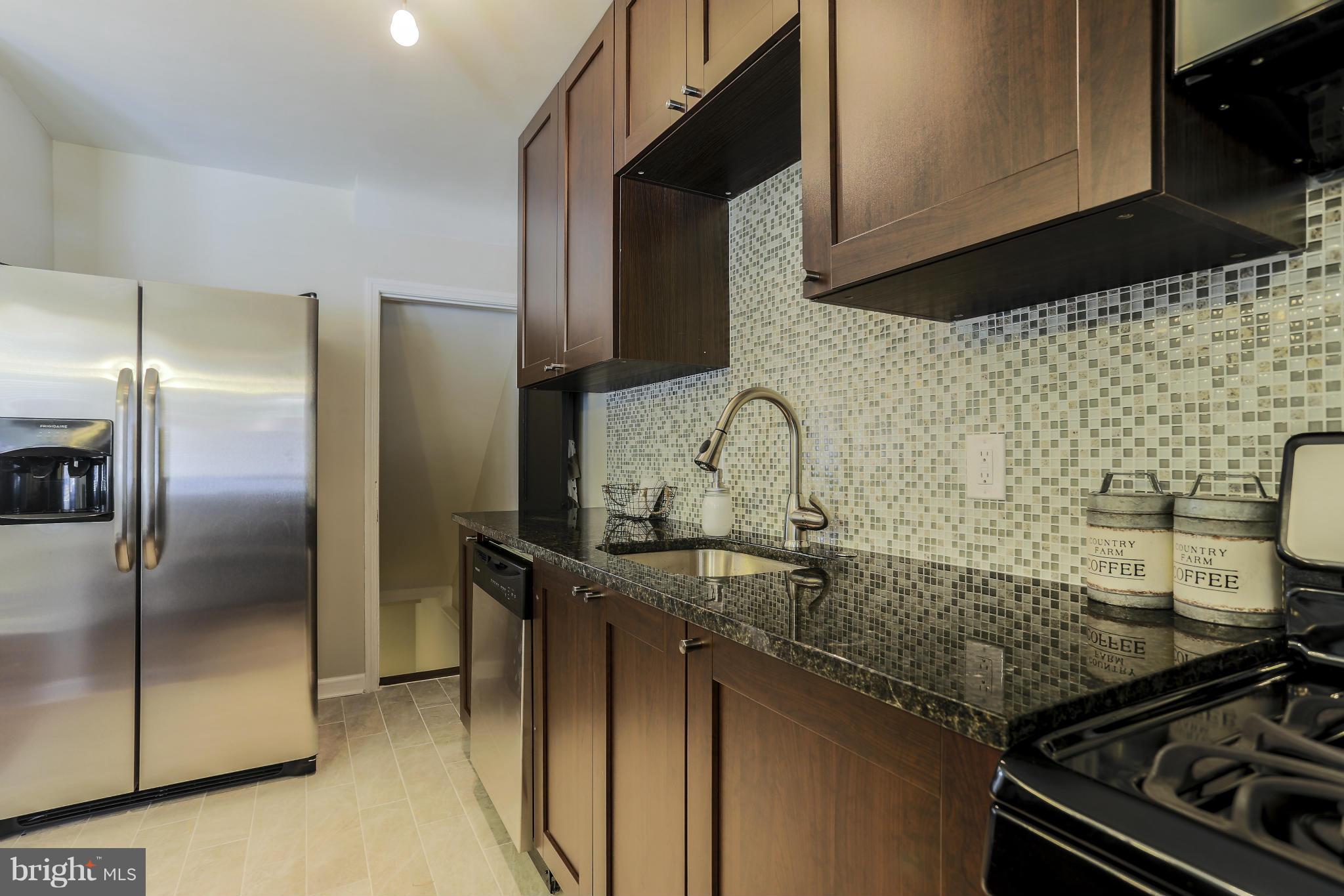 6923 Belclare Road Baltimore, MD 21222 - Photo 10 of 23 a kitchen with granite countertop a sink stove and refrigerator