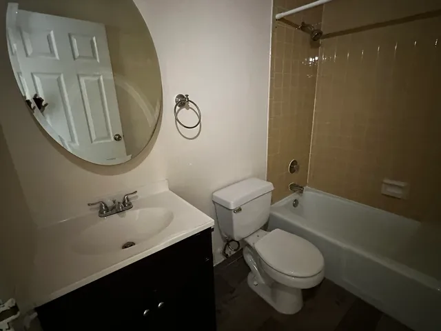 a bathroom with a toilet sink vanity tub and shower