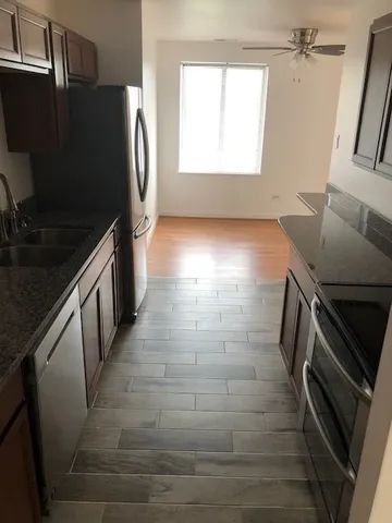 a kitchen with granite countertop a refrigerator and a stove