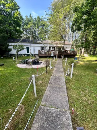 a view of swimming pool with lawn chairs and plants