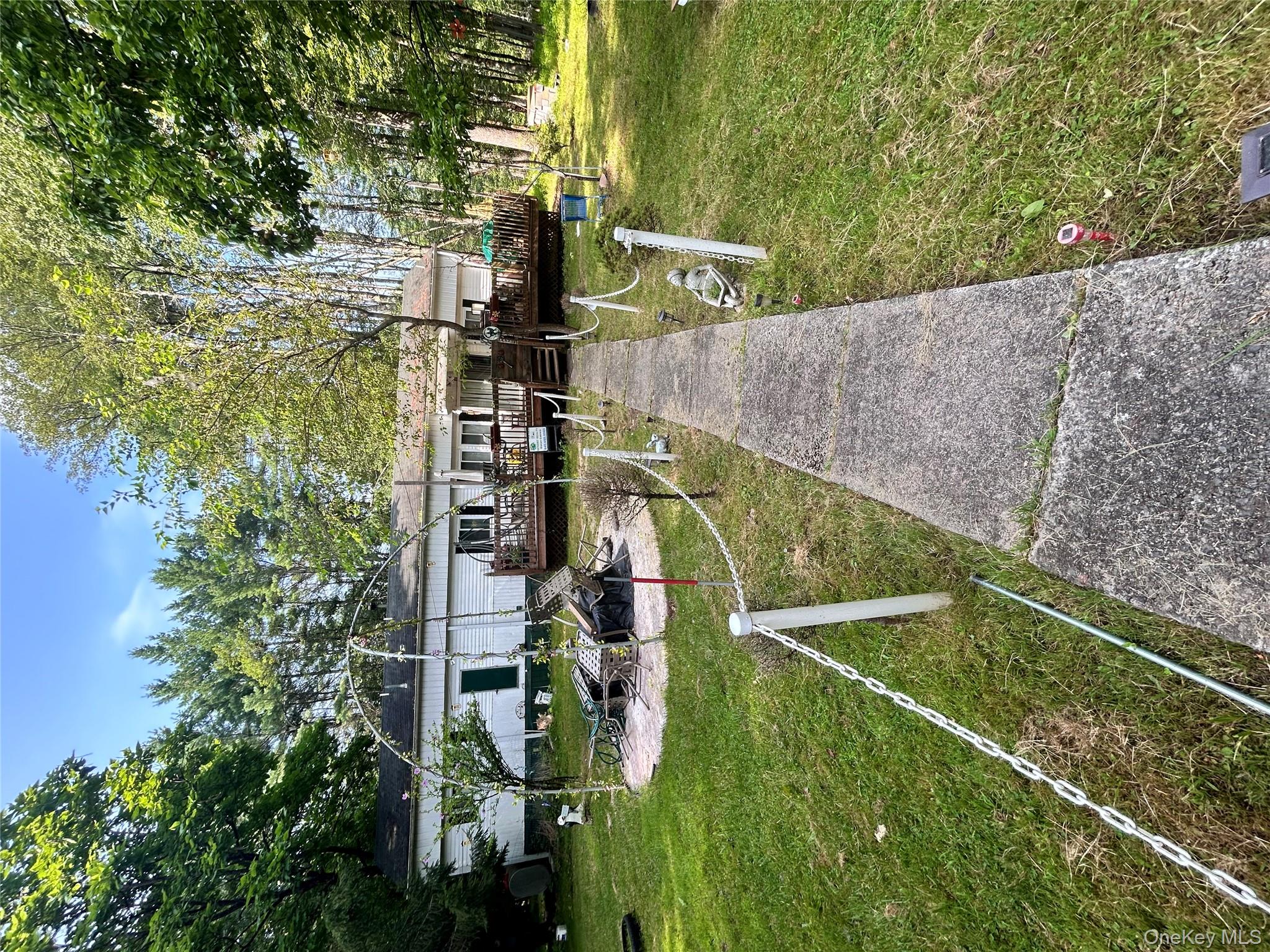 a view of swimming pool with lawn chairs and plants