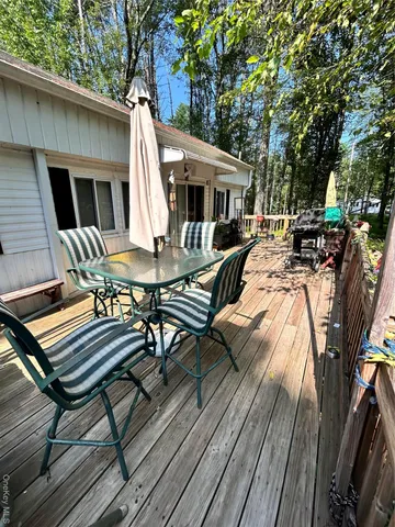 a view of a patio with table and chairs with wooden floor and fence