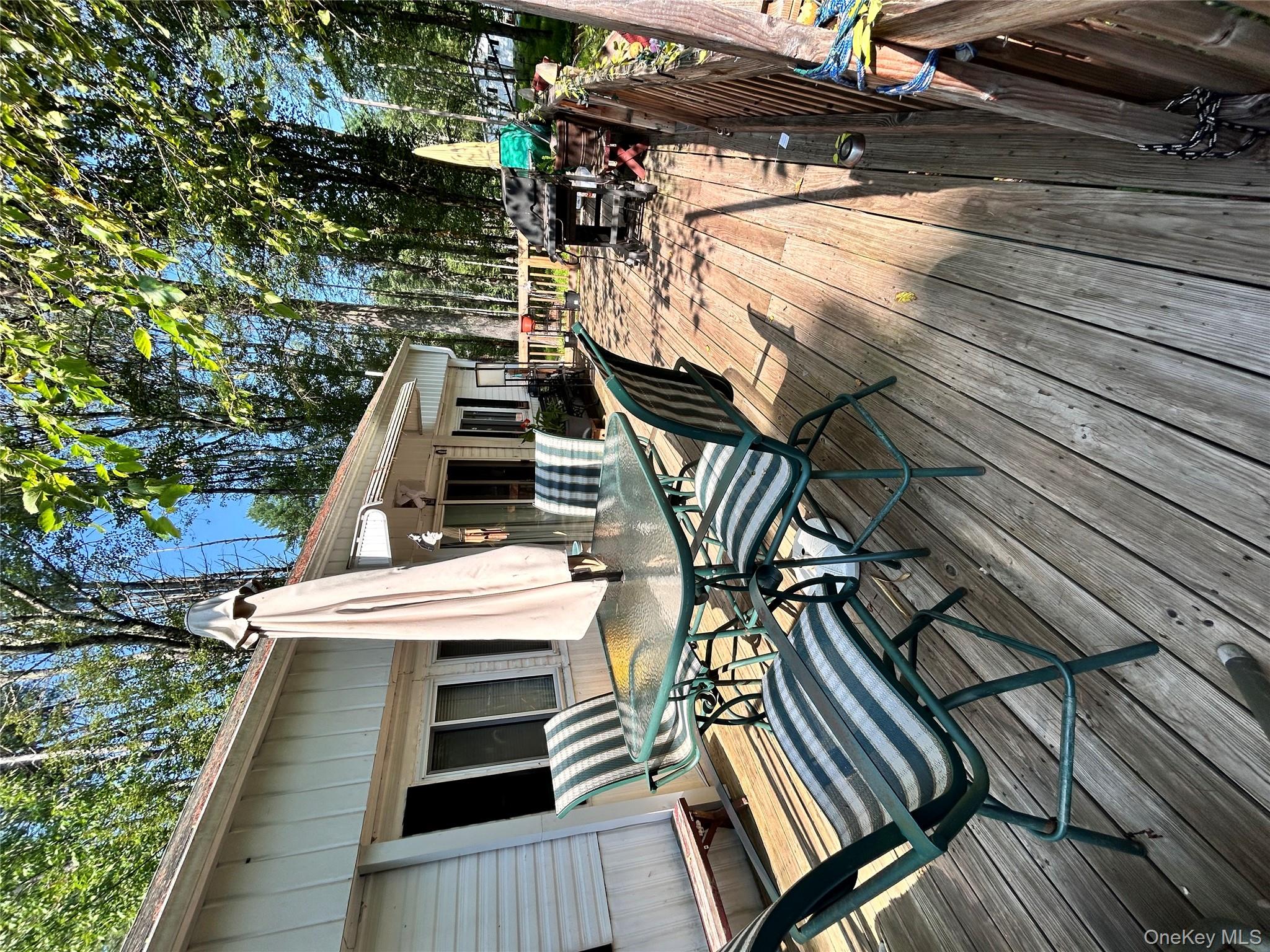 98 Buff Road Cochecton, NY 12726 - Photo 2 of 13 a view of a patio with table and chairs with wooden floor and fence