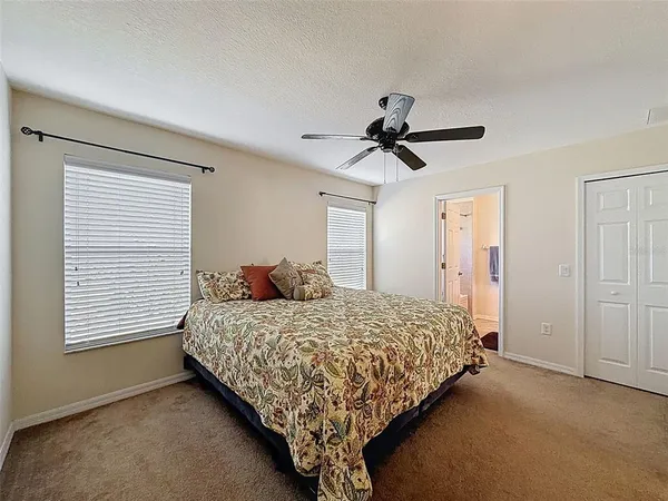 a bedroom with a bed a ceiling fan and a dresser