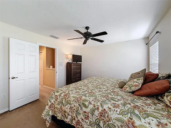 a bedroom with a bed and a ceiling fan