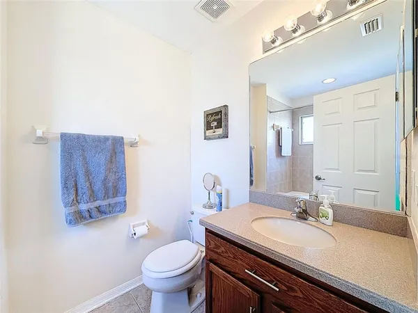 a bathroom with a granite countertop sink a toilet and a mirror
