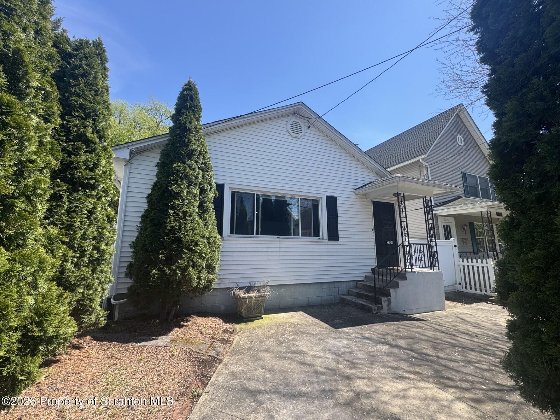 2220 Capouse Avenue Scranton, PA 18509 - Photo 18 of 18 a front view of a house with a yard outdoor seating and covered with trees