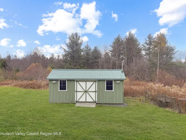 a view of a house with a big yard and large trees
