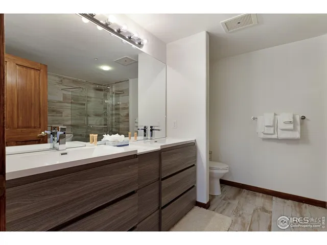 a bedroom with a bed a mirror and a large window