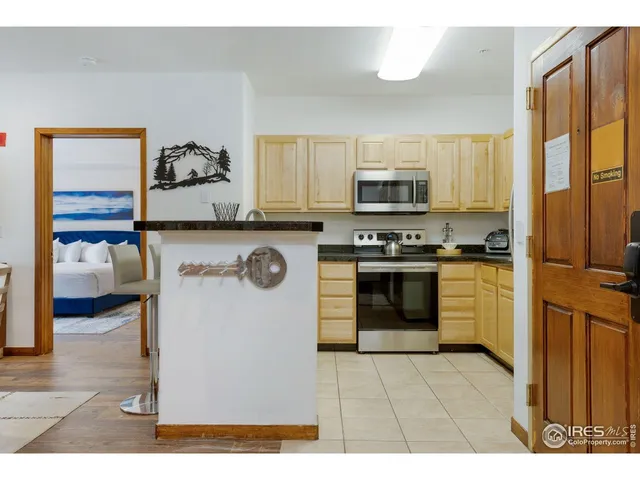 a view of kitchen with refrigerator and chairs